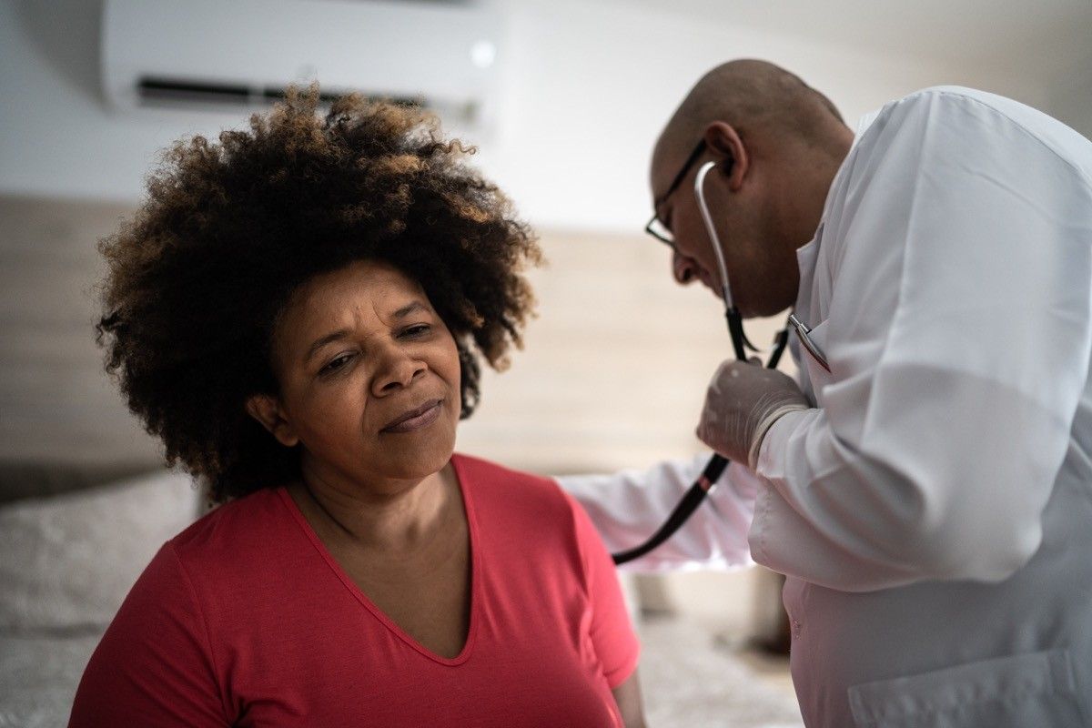 Um médico ouve os batimentos cardíacos de um paciente