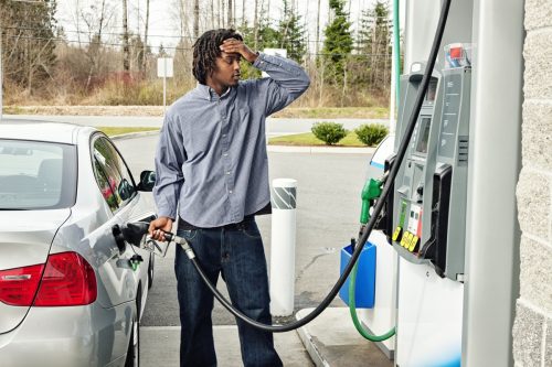 stressed man at gas pump