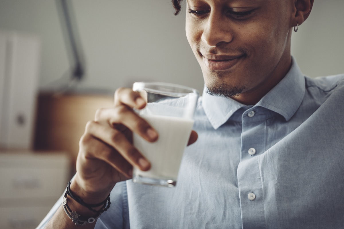 Young man at home drinking milk