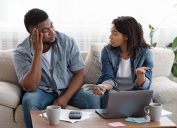 ouple accounting family budget at home, wife scolding her husband for overspending and lack of money