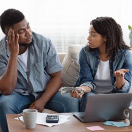ouple accounting family budget at home, wife scolding her husband for overspending and lack of money