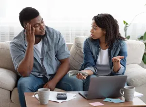 ouple accounting family budget at home, wife scolding her husband for overspending and lack of money