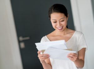 woman at home checking her mail and looking very happy - lifestyle concepts