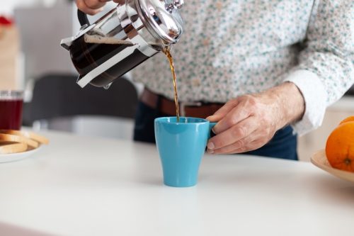 person making coffee using french press