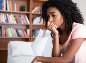 woman sitting on couch, looking sad or nervous