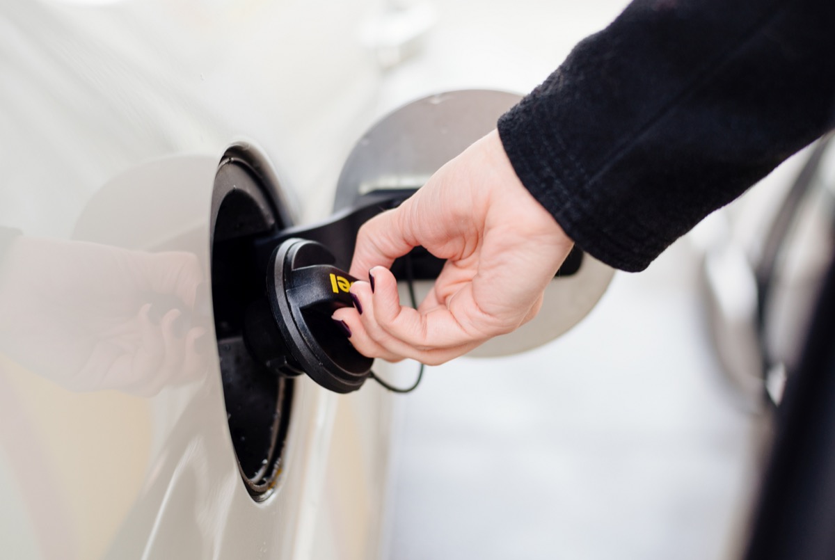 Woman opening diesel fuel cap at the gas station