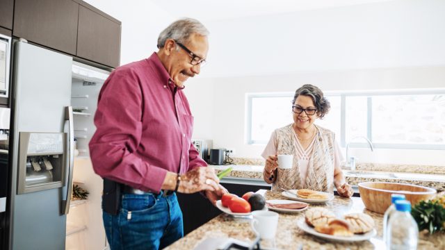 A senior couple preparing food in the kitchen