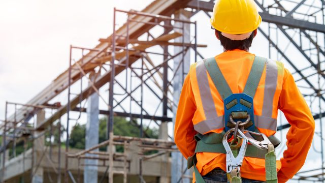 Construction worker in safety harness and hard hat