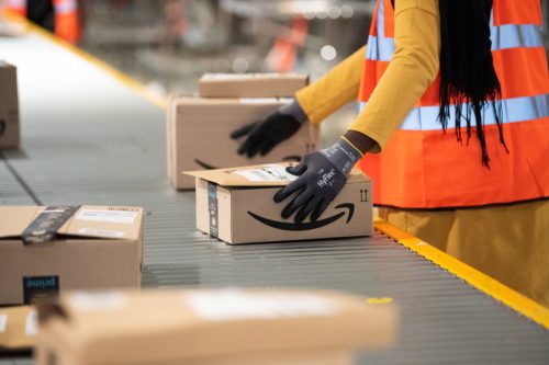 close up of amazon worker handling box at factory