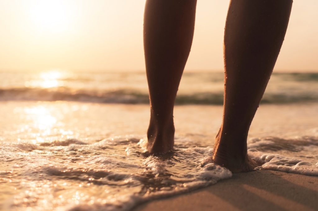 close up of legs walking into the ocean