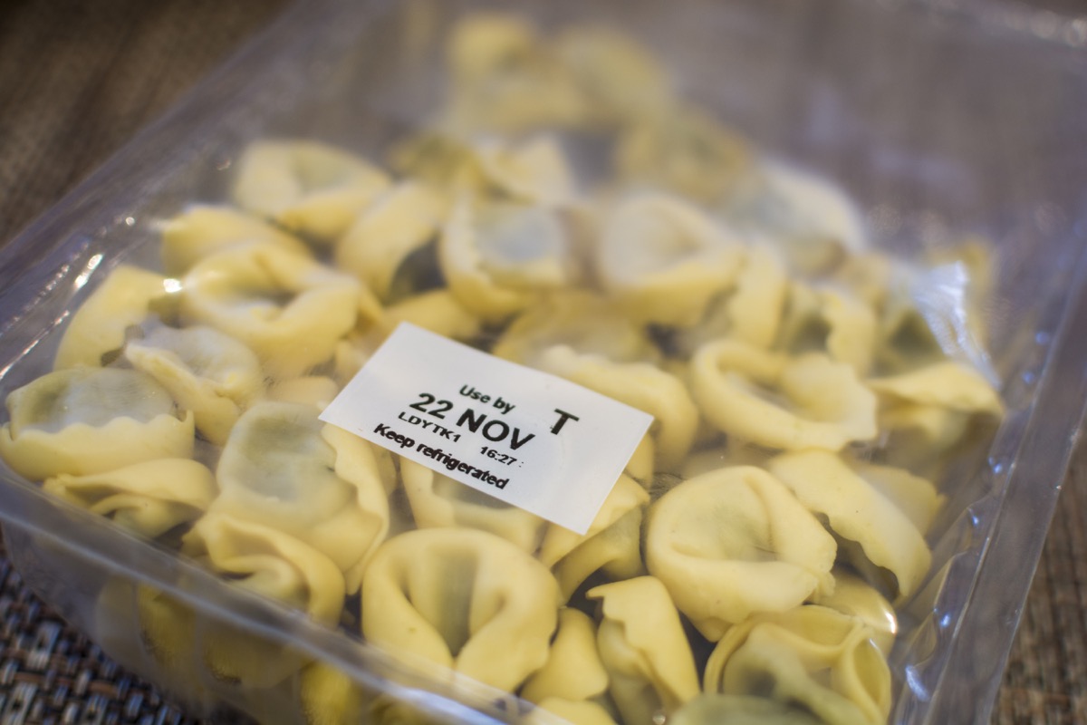 A vacuum sealed packet of pasta shells. Use By date stamp says "22 NOV" and some other text.