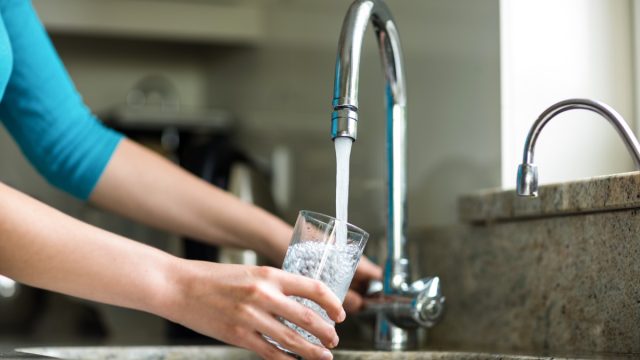 Woman getting water from sink