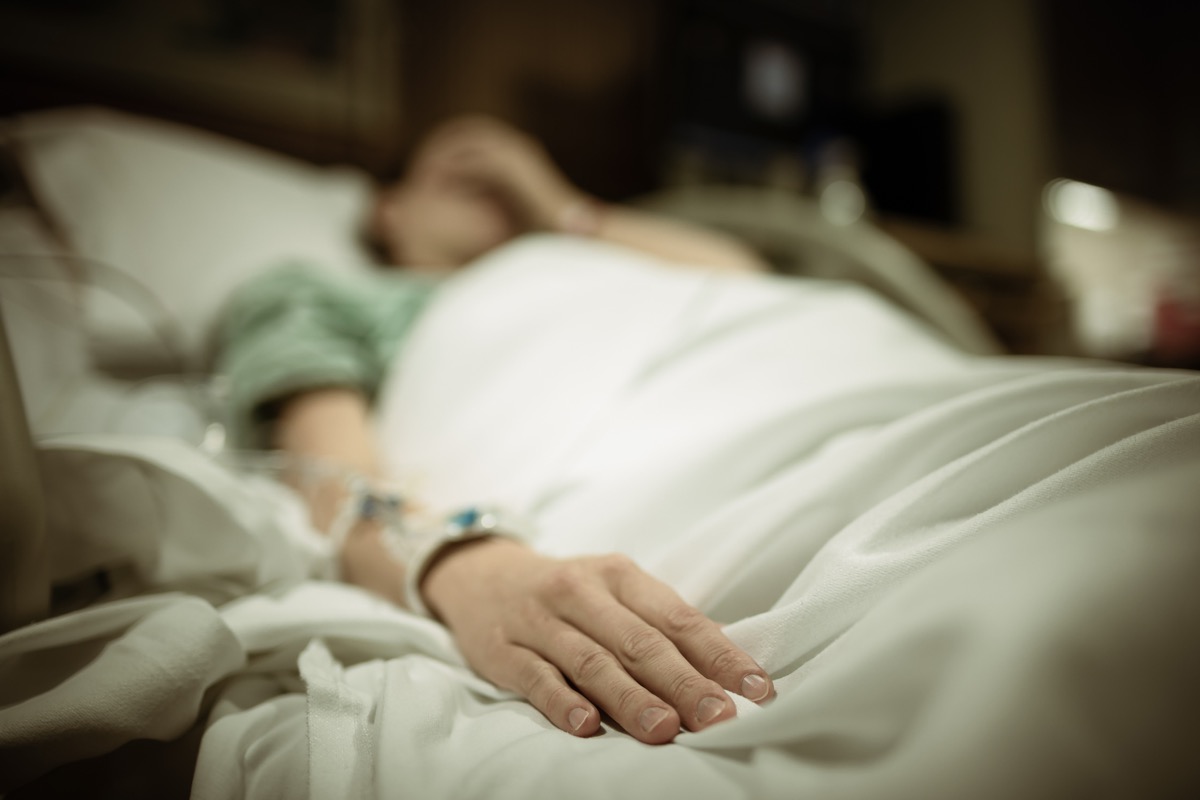 woman in hospital bed with hand on her head