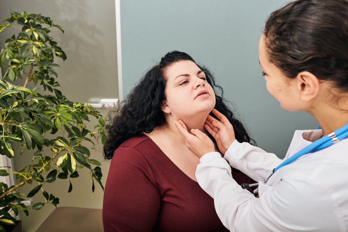 woman gets neck checked by doctor
