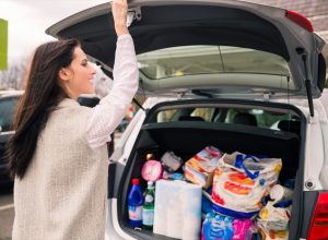 woman packing groceries into the trunk of her car