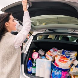 woman packing groceries into the trunk of her car