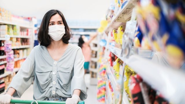 woman wearing mask, shopping for snacks