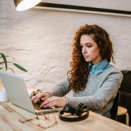 young woman reading report on laptop.
