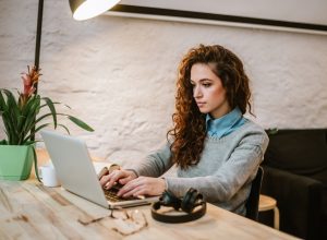 young woman reading report on laptop.