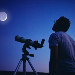 Man looking at moon with telescope