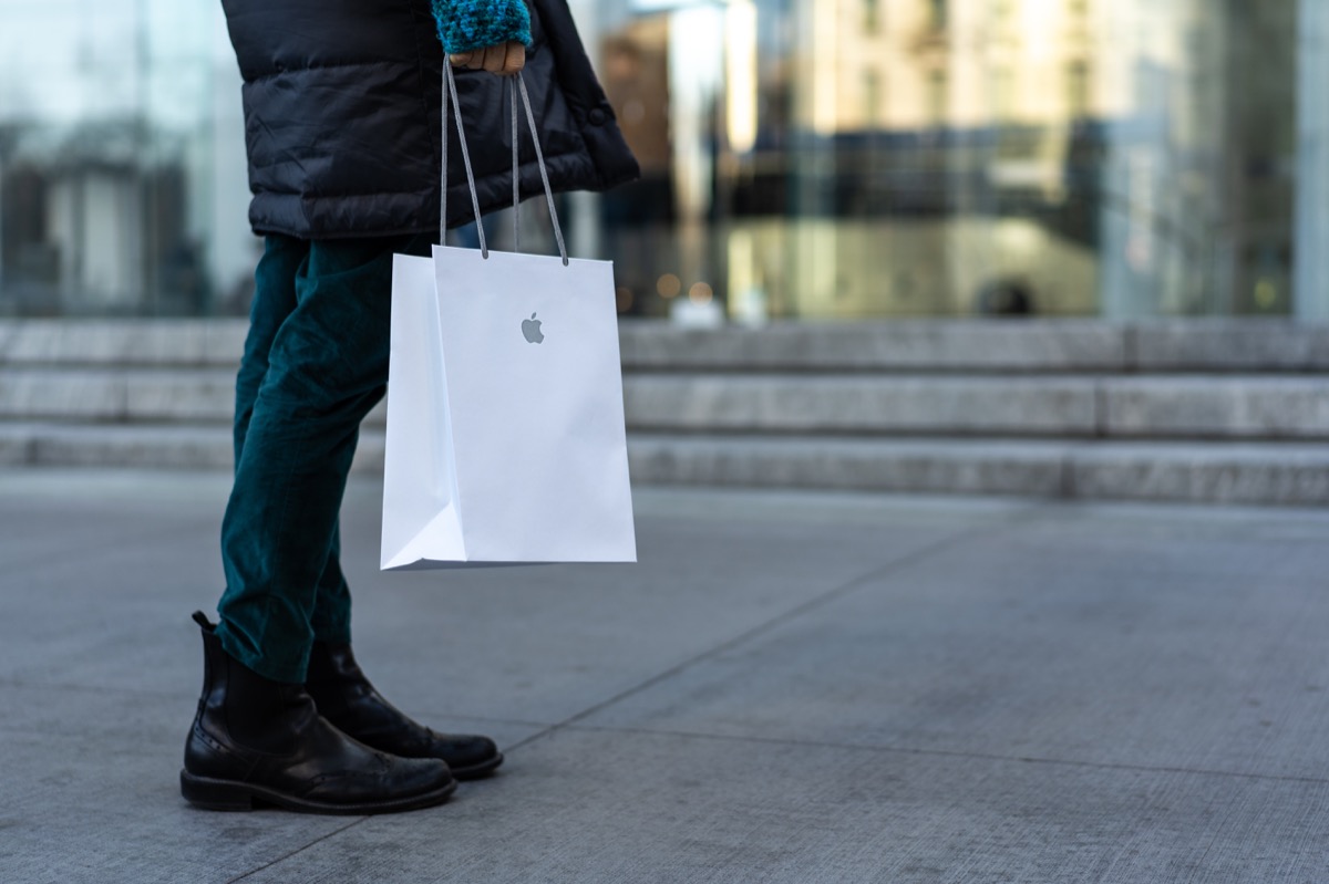 Shopper walking with an Apple store bag