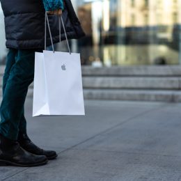 Shopper walking with an Apple store bag