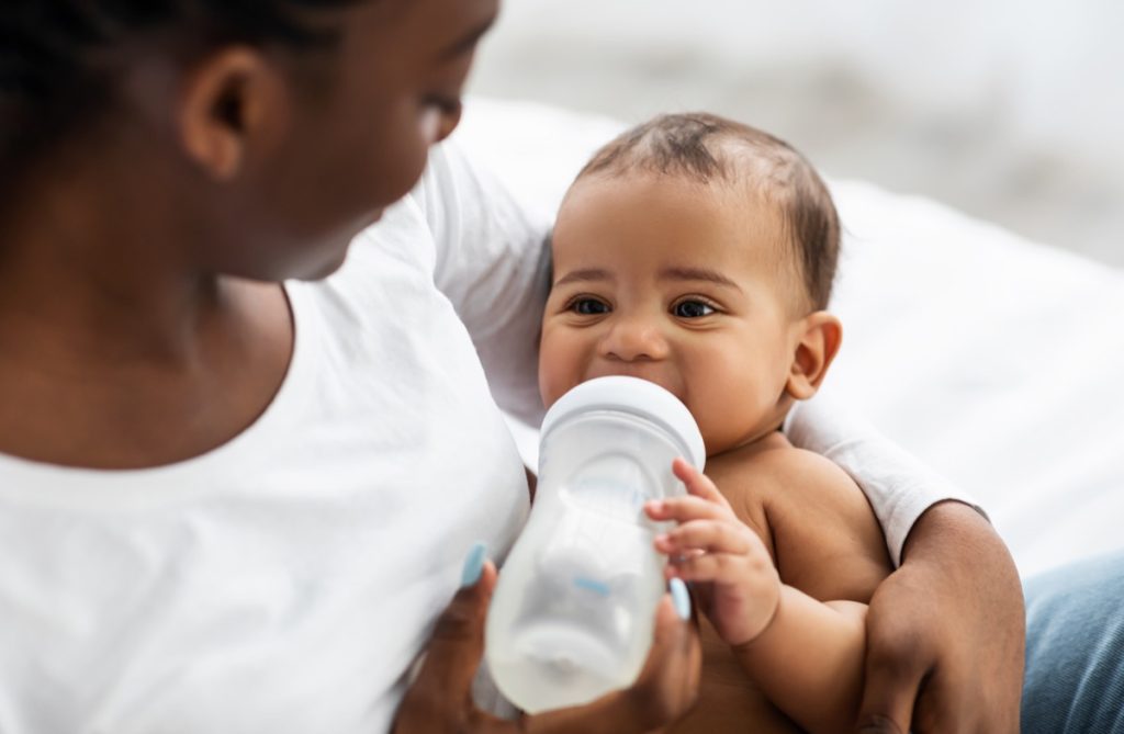 mother feeding infant bottle