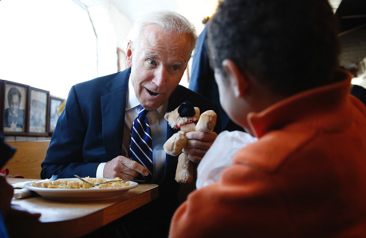 Then Vice President Joe Biden gives a young boy a stuffed version of Biden's dog, Champ, while visiting a diner March 26, 2014 in Washington, DC. Biden visited the Florida Avenue Grill to highlight the administration's efforts to raise the national minimum wage to $10.10 an hour.