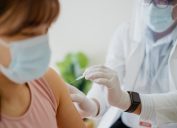 woman getting a vaccine injection on her arm from a healthcare worker