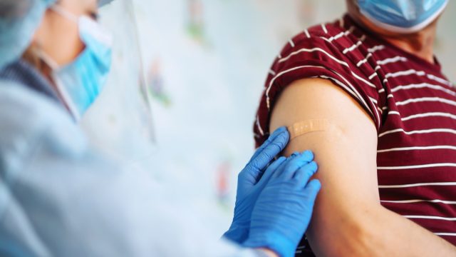 man receiving bandaid after COVID vaccination