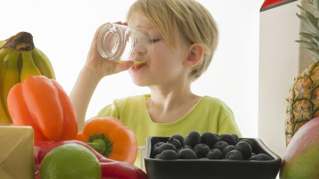 Thirsty child drinking orange juice from the refrigerator.