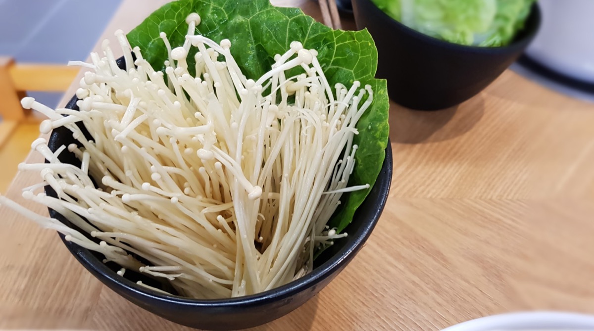enoki mushrooms with leafy greens in bowl