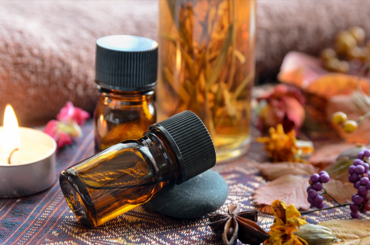 essential oils in amber bottles next to dried flowers