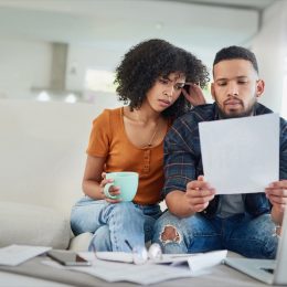 Shot of a young couple looking stressed while going over their finances at home