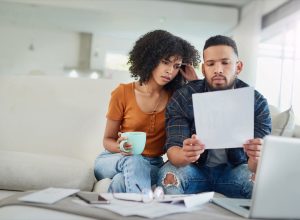 Shot of a young couple looking stressed while going over their finances at home