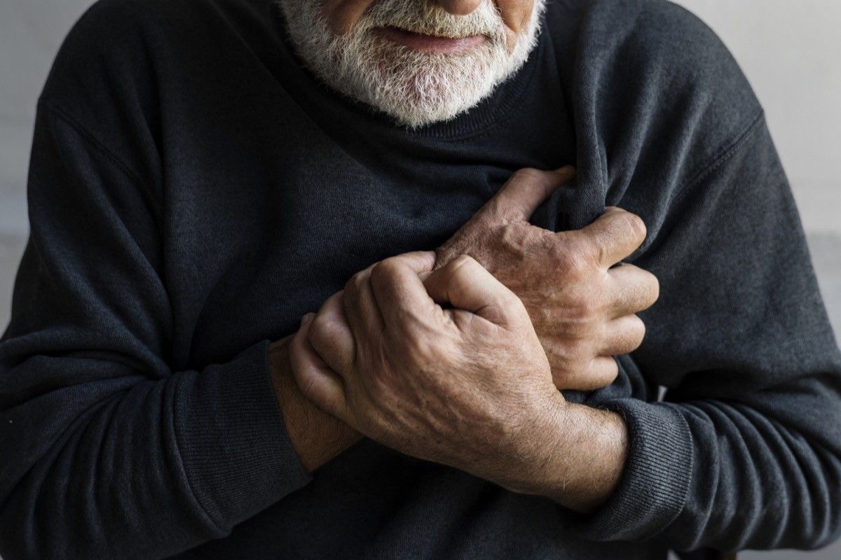 Closeup of elderly man having heart attack chest pain