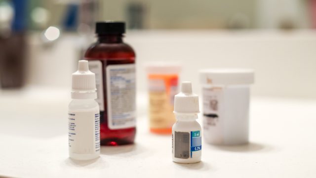 5 Different bottles of medicine sitting on a white bathroom counter