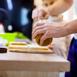 Close-up of unrecognizable father making peanut butter sandwiches for his 6 year old son