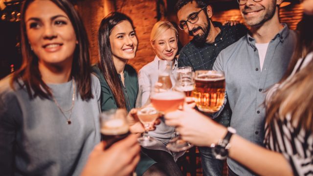 A group of friends raising a toast with drinks in a bar