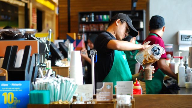 SEREMBAN,MALAYSIA - SEPTEMBER 18, 201T: Worker at Starbucks Cafe preparing coffee for customers.Starbucks is an American global coffee company and coffeehouse chain based in Seattle, Washington