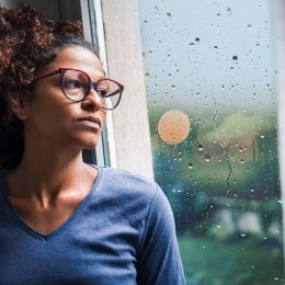 Woman looking out window during a storm