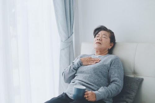 older woman sitting down and having breathing trouble