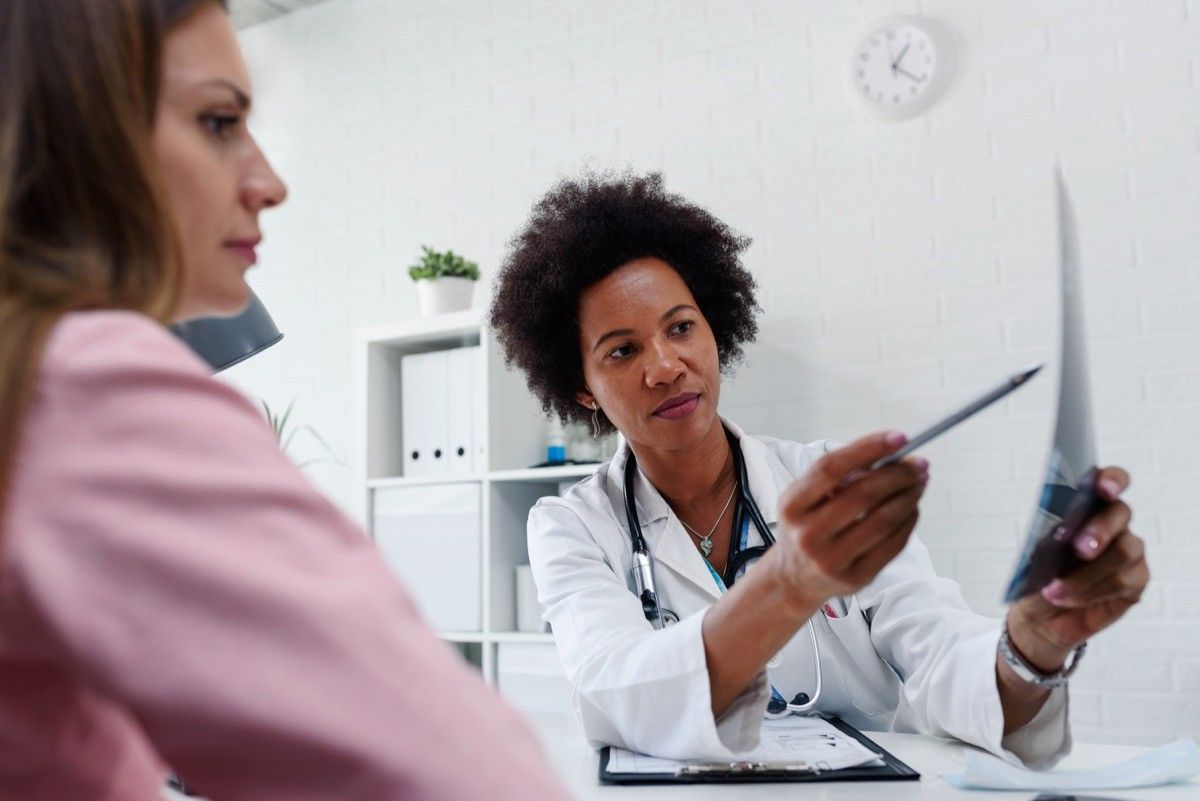 Female doctor looking at test results of her patient. Breast examination. Mammogram. Health care concept, medical insurance. Womens health.