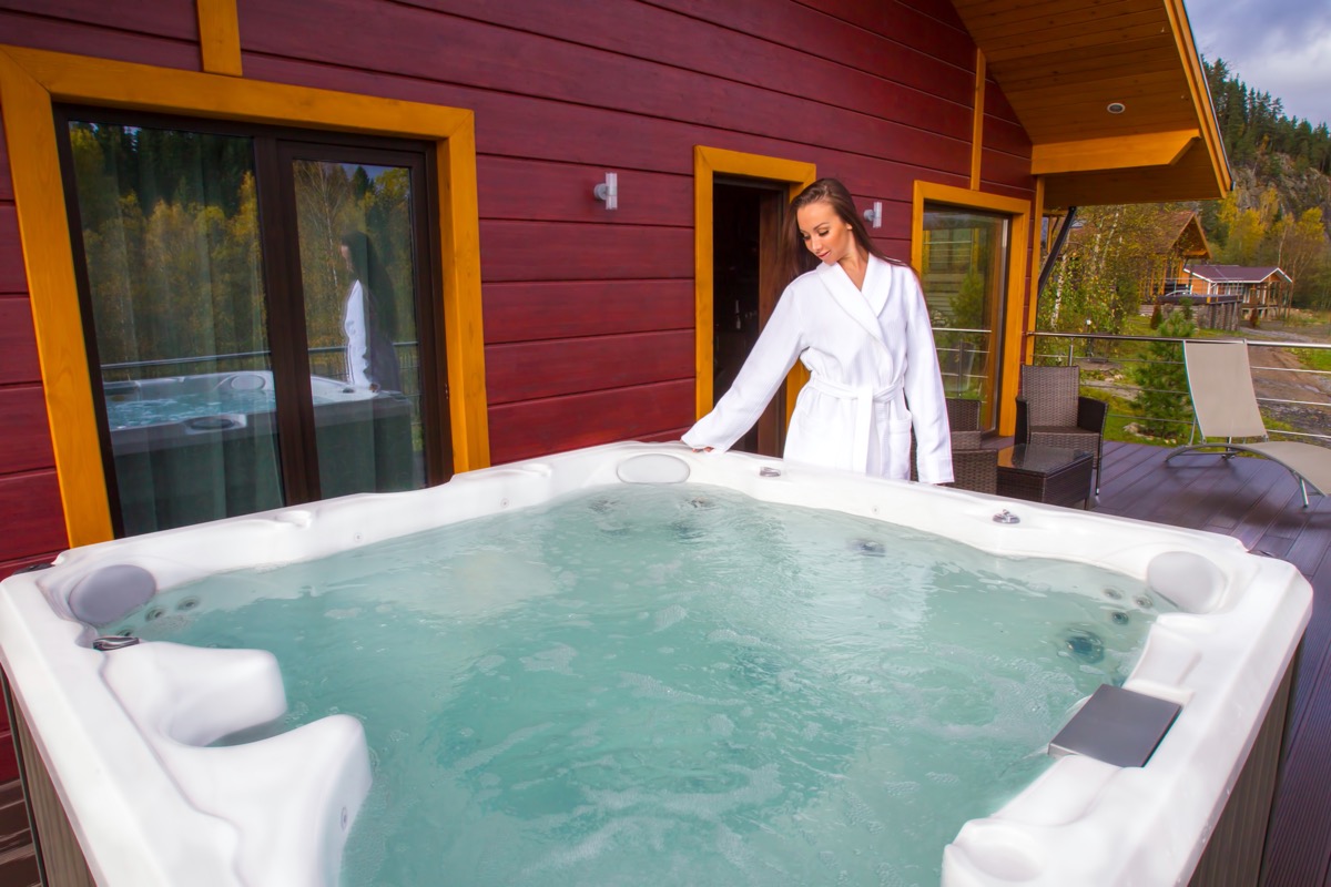 woman in white robe standing near hot tub