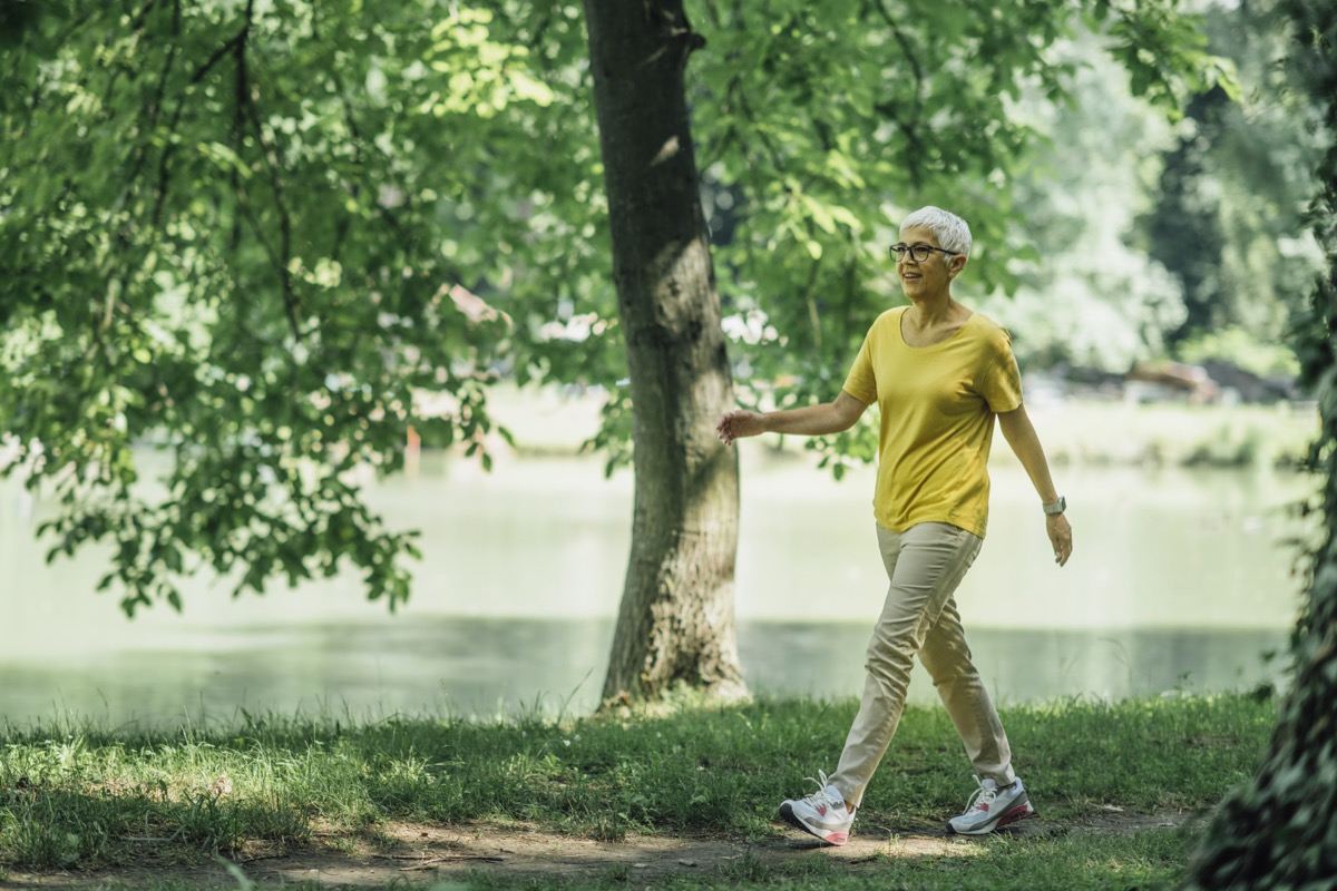 Mujer madura disfrutando de ejercicio para caminar junto al lago
