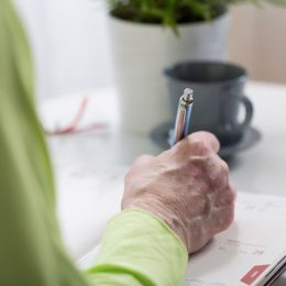 Older person writing on paper