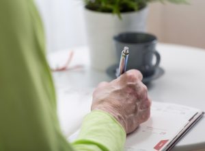 Older person writing on paper
