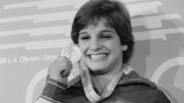 Mary Lou Retton holding up Olympic gold meal in 1984