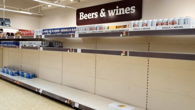 Shelves nearly empty of beer at a supermarket in as shoppers purchase supplies amid the coronavirus pandemic.