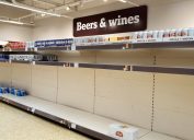 Shelves nearly empty of beer at a supermarket in as shoppers purchase supplies amid the coronavirus pandemic.